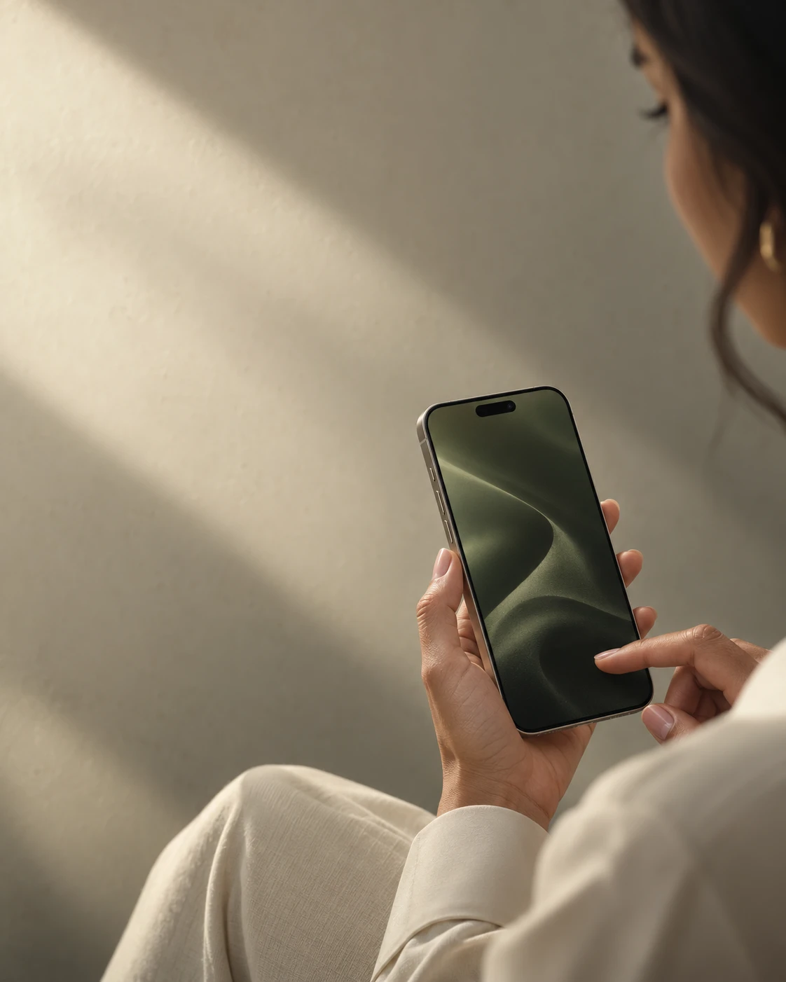 A close-up of a woman using her iPhone in soft afternoon light.